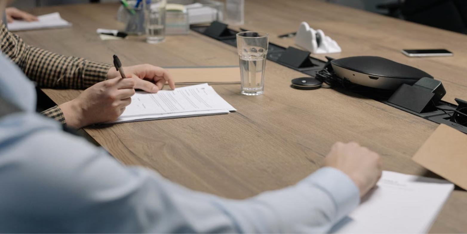 Business owner signing notarized documents during a meeting